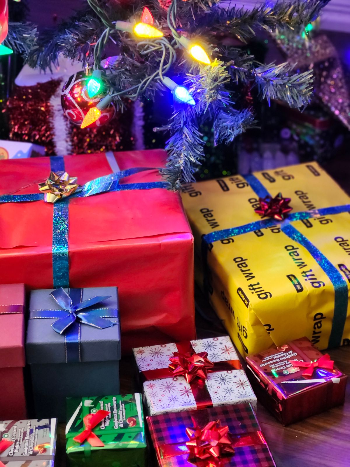 Festive wrapped gifts with colorful lights and Christmas decor create a joyful holiday ambiance.