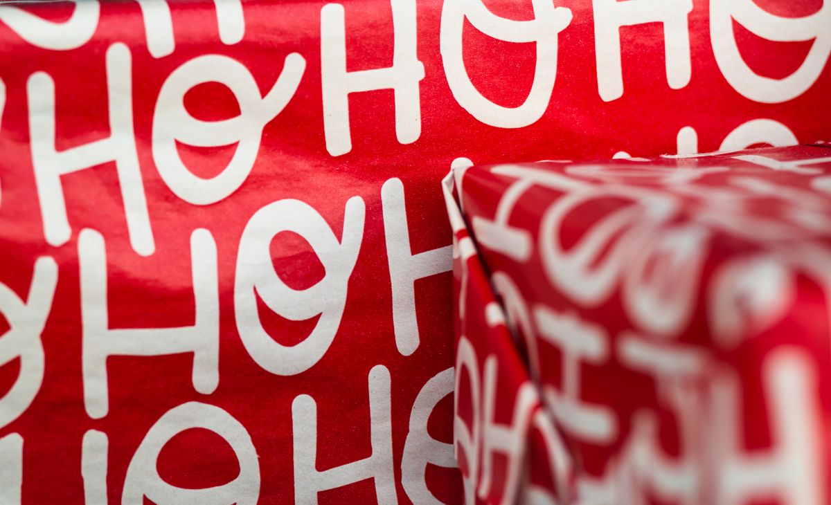 Red wrapping paper featuring festive Ho Ho Ho design, perfect for Christmas gifts.