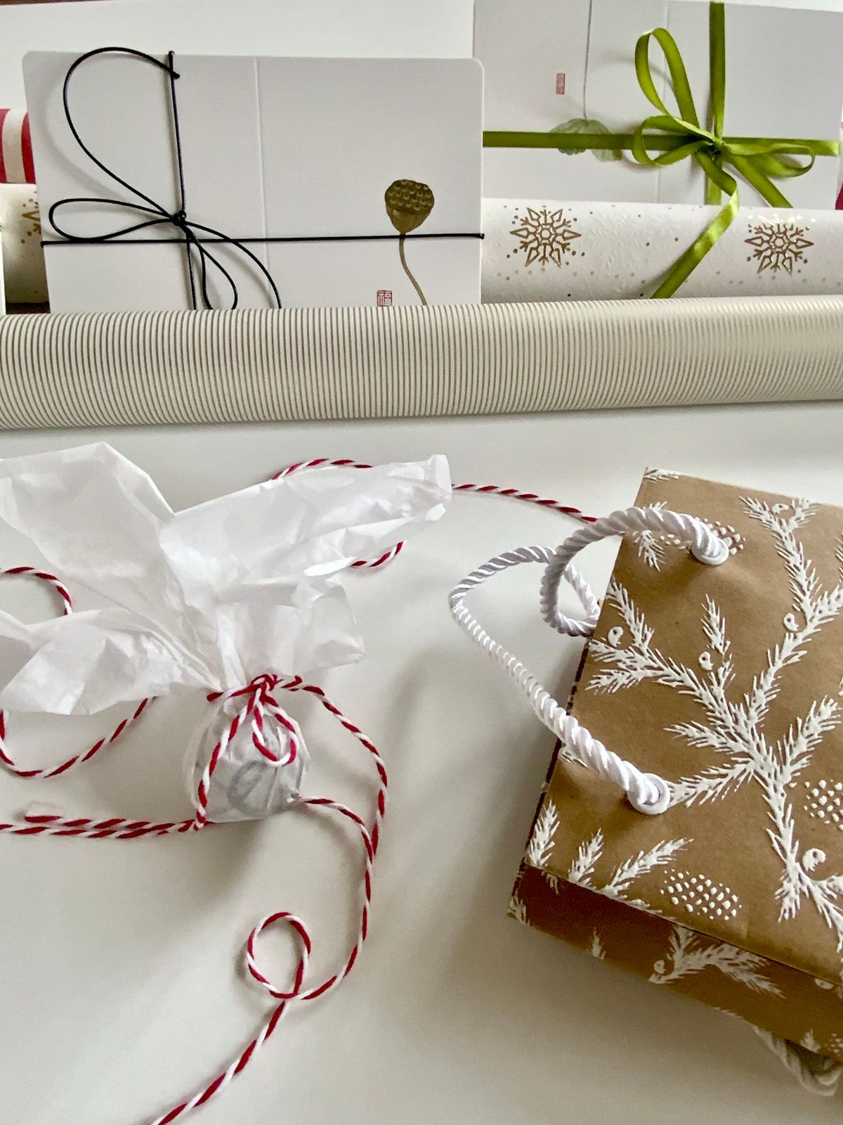 Festive gift wrapping scene with kraft paper, ribbons, and decorative bags.